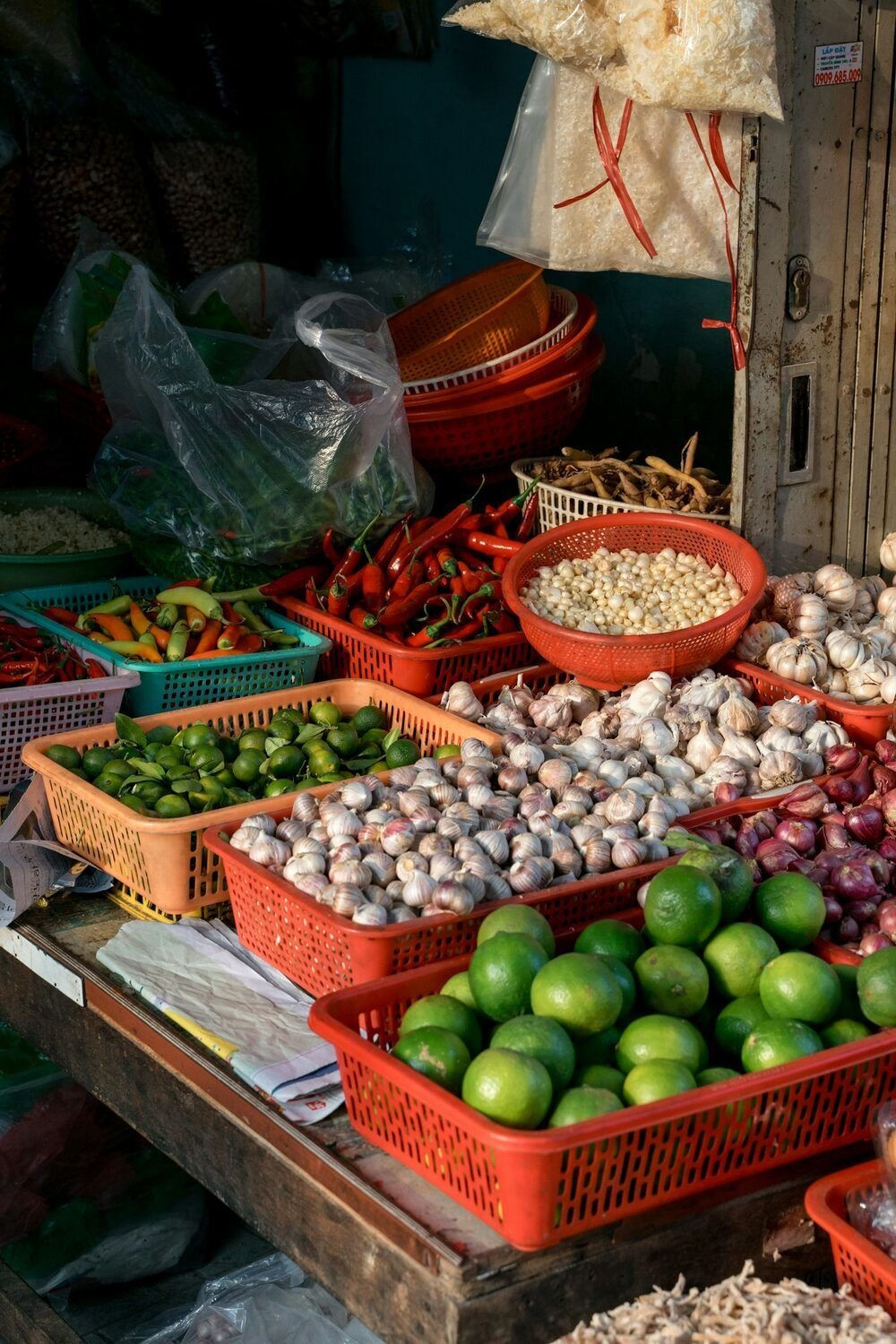 Chanh, tỏi, hành tím và ớt trong những chiếc rổ nhựa ở một sạp chợ Sài Gòn